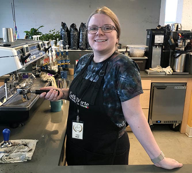 Photo of Lexi, Everett Recovery Cafe's Barista Program Manager behind the coffee station.