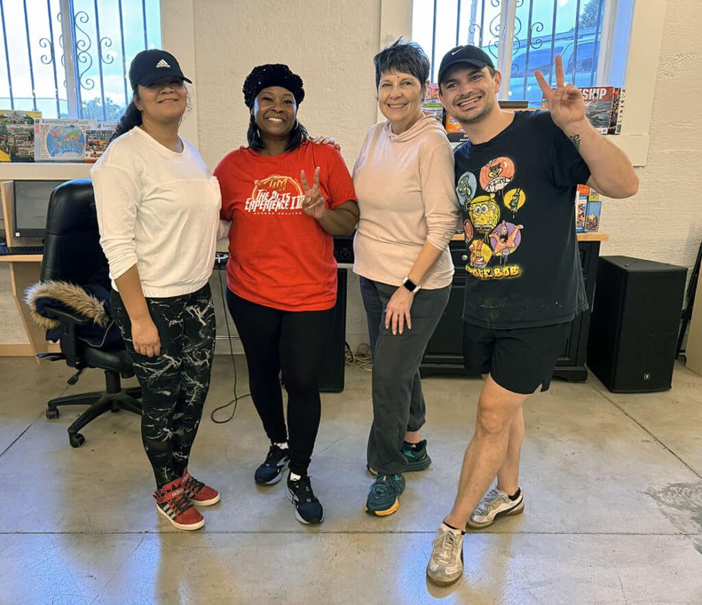 Four smiling individuals pose for a picture in Everett Recovery Cafe after a Zumba class.