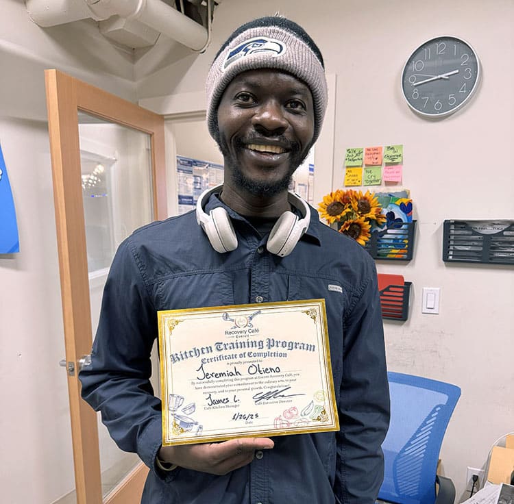 A man shows his kitchen training certificate.