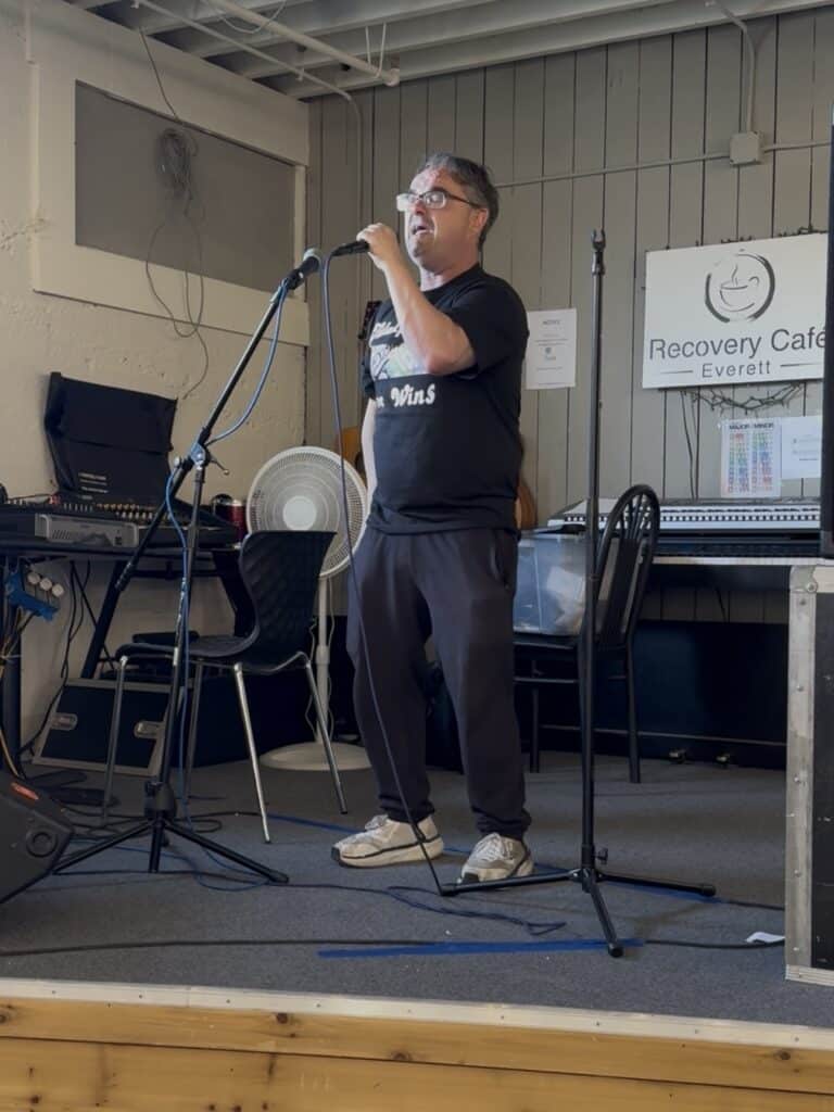 a man standing on a stage holds a microphone during a performance